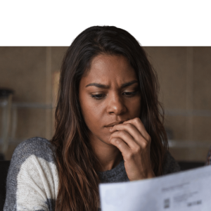 Woman in contemplative pose reviewing documents, representing engagement with workplace wellbeing resources