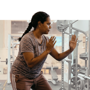 Woman in athletic stance during a boxing fitness class against purple background