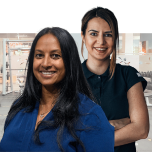 Two smiling women against a purple background, representing diverse team members for workplace wellbeing programs
