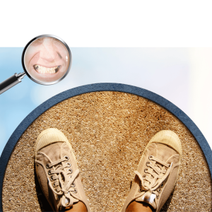 Person standing on sandy ground wearing hiking boots with magnifying glass showing smiling face reflection above