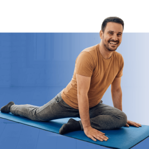Instructor smiling while leading a fitness class for a diverse group of participants on exercise mats